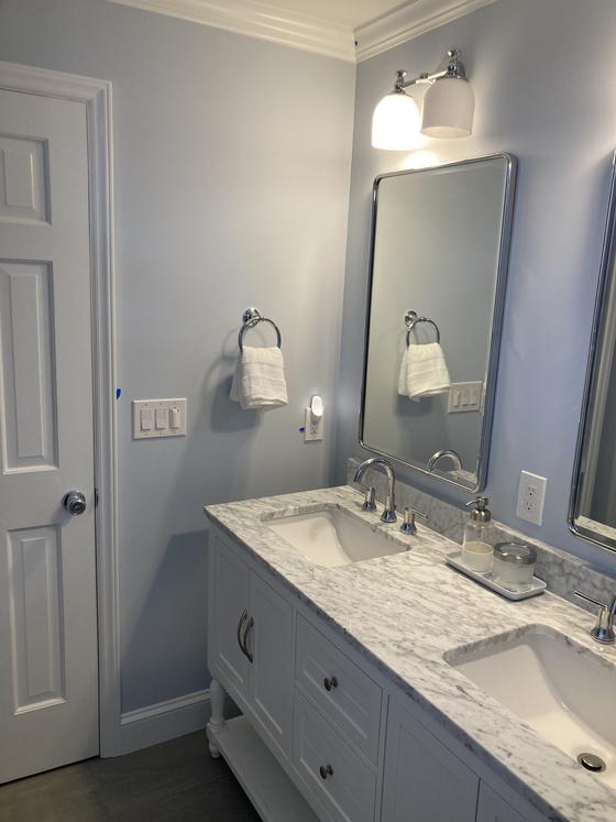 Bathroom with a double vanity, marble countertop and framed mirrors