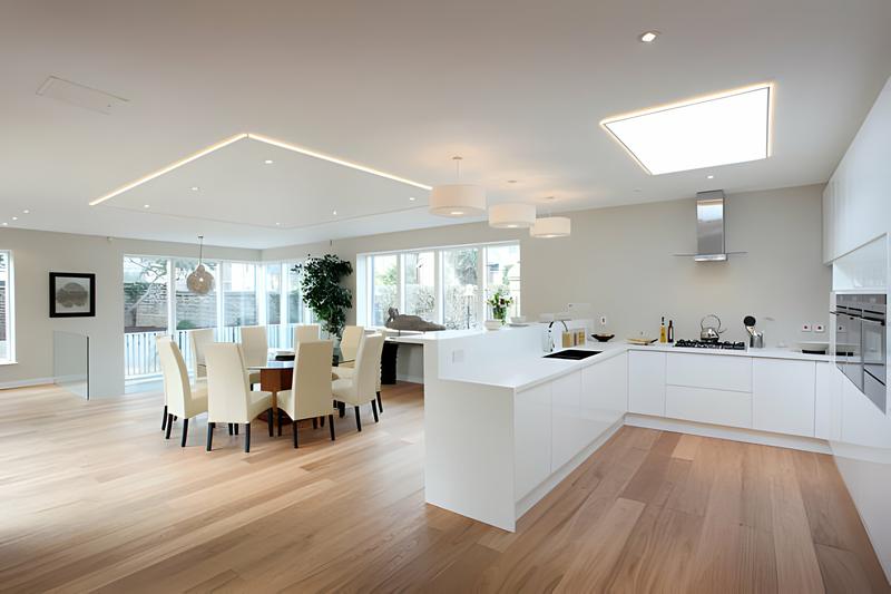 Open-concept kitchen and dining room with a skylight and wide-plank wood floors