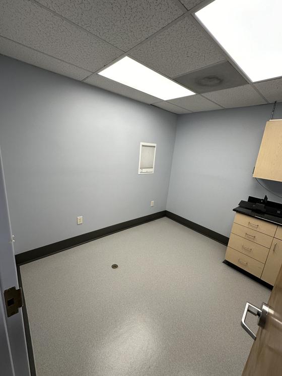 Renovated interior room with fresh paint, new flooring and a drop ceiling