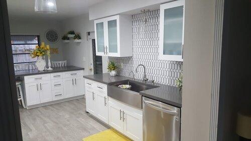 Kitchen with dark countertops, a farmhouse sink and patterned backsplash tile