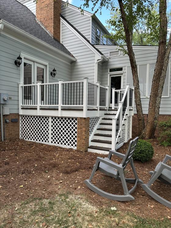 Rear deck with white railings, stairs and lattice skirting